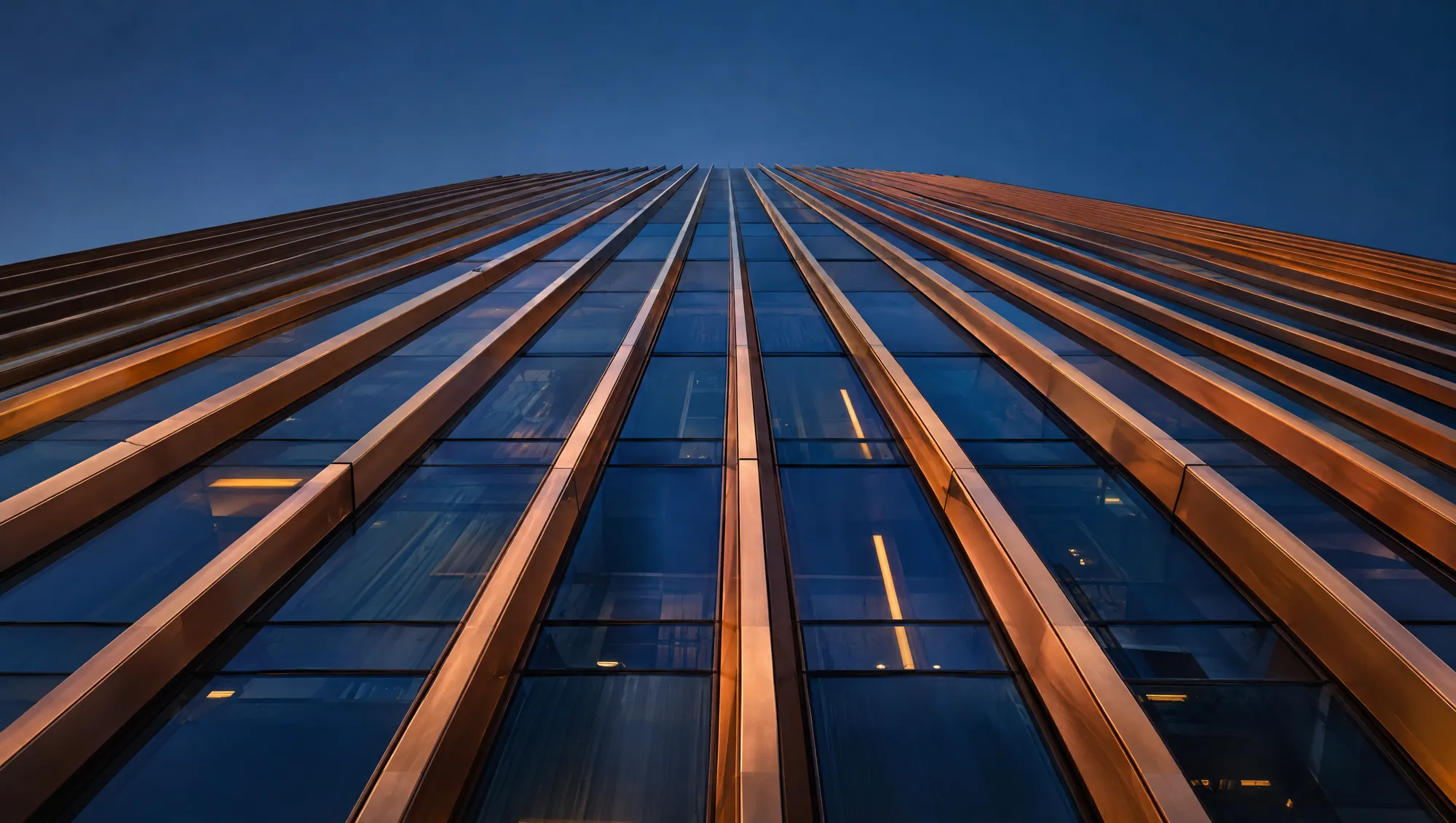 Bronze fins of the Halcyon facade rising into a blue dusk sky